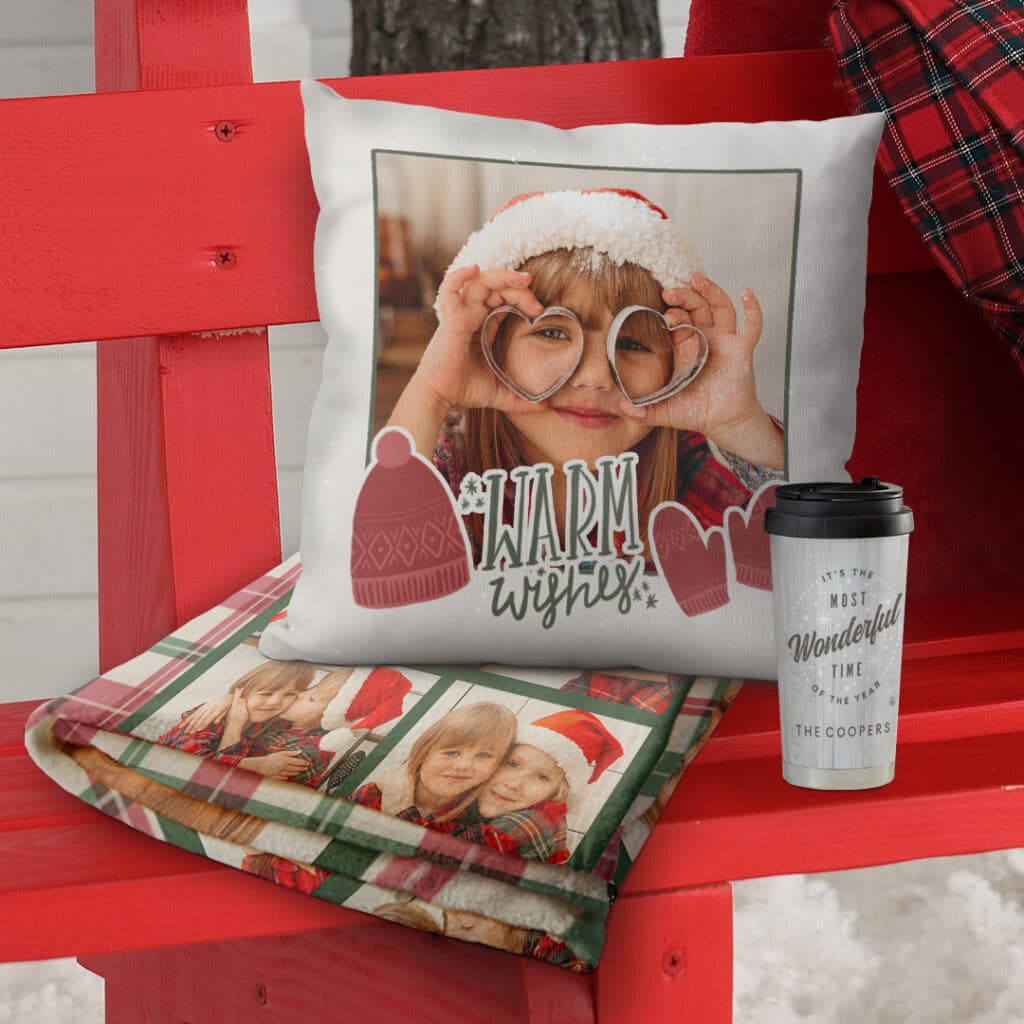 a personalised blanket and a cushion on an outdoor red bench