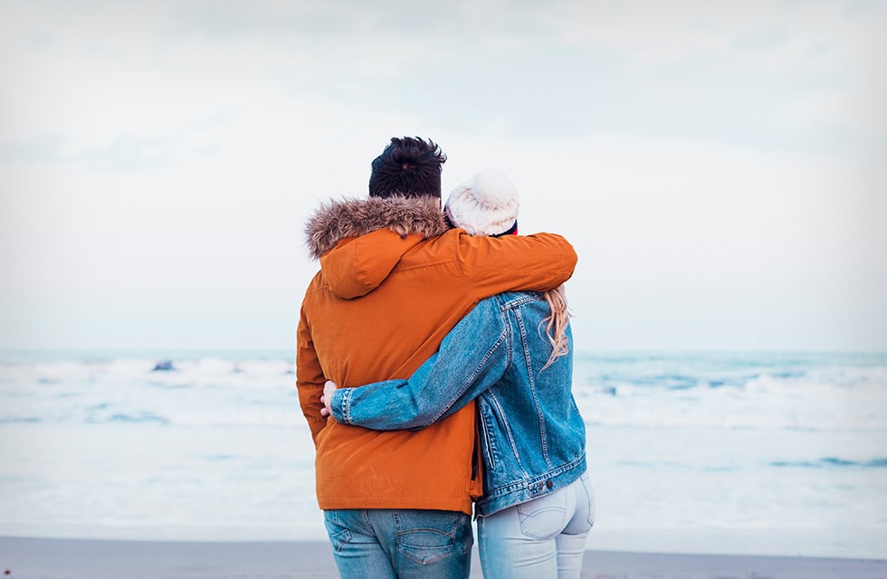 A couple embracing while overlooking the ocean