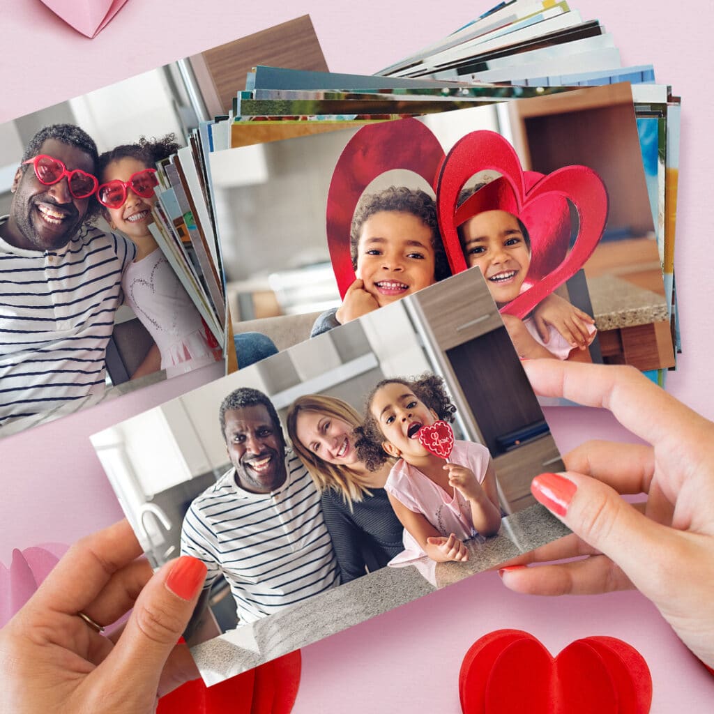Pile of photo prints with a hand holding a print