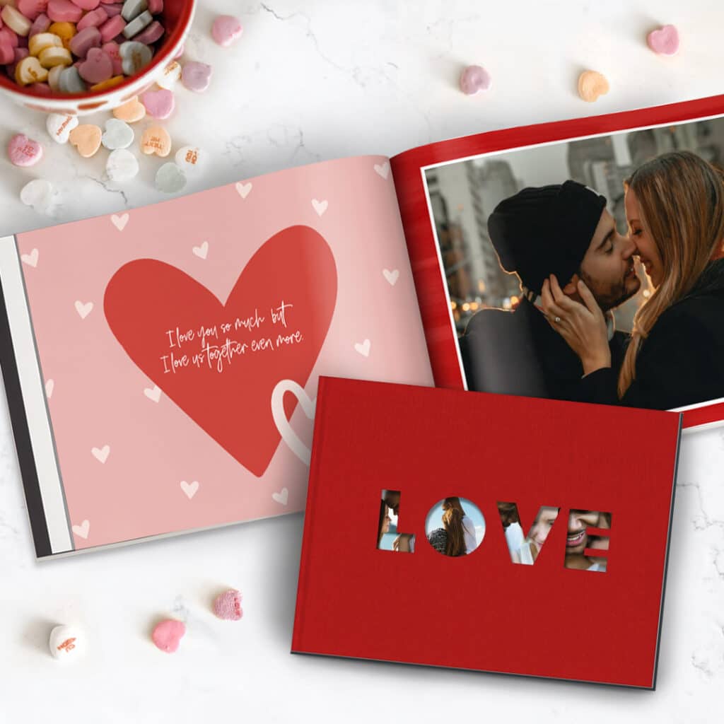 Photobooks laid out on a table with heart sweets scattered around