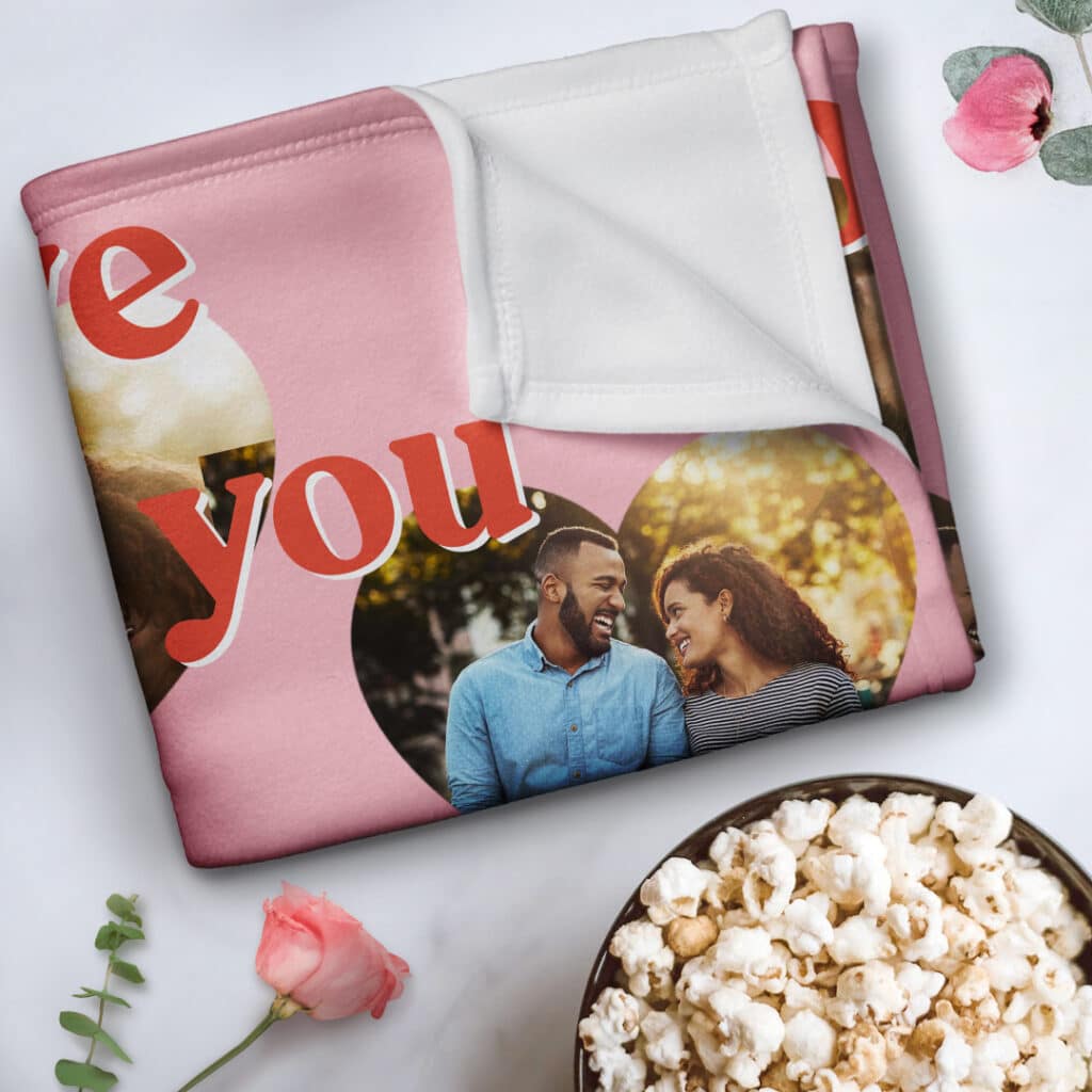 A personalised blanket folded neatly next to a rose